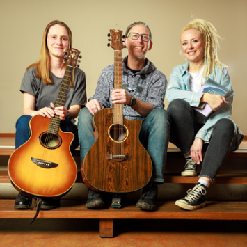 eine Frau und ein Mann mit ihren Gitarren und eine Sängerin